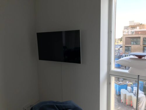 Væg-installation af TV i stue med kabelbakke